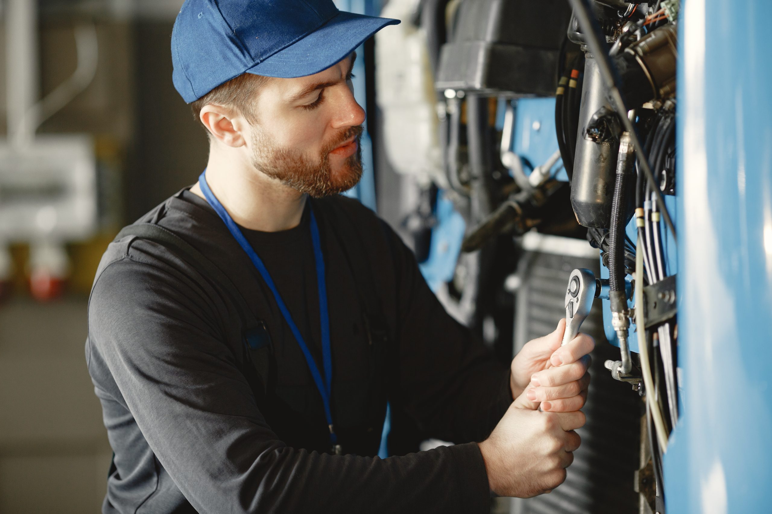 Сar mechanic repairs blue car in garage with tools